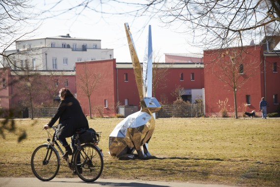 Radfahrer im Röthelheimpark vor der Hasenskulptur
